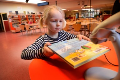 Meisje levert boek in bij bibliotheek op school